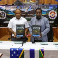 MEHRD Minister Hon. Stephen Kumi and Malaita Premier Hon. Elijah Asilaua, holding the signed Agency Agreement between MEHRD and the Malaita Provincial Government.